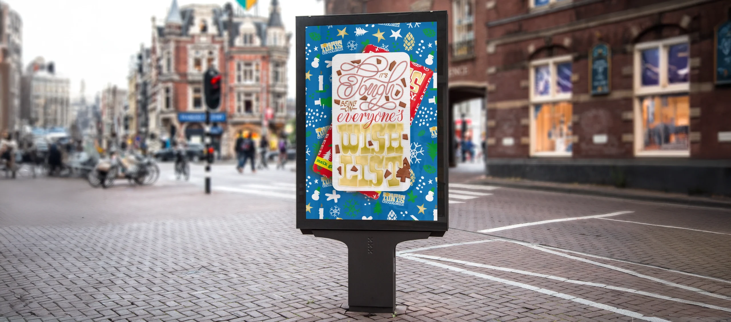 Mock-up depicting the lettering piece on an Abri situated in Amsterdam. Text: It’s Tough Being on Everyone’s Wishlist. Part of Portfolio Item: Christmas Message Tony's Chocolonely